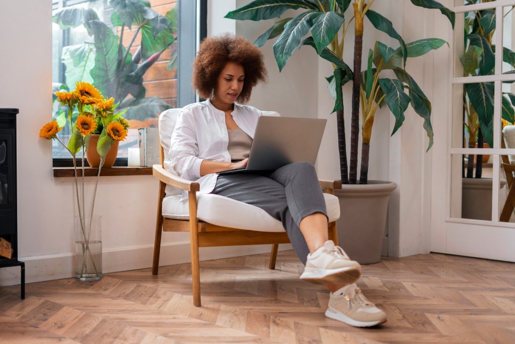 woman sitting in a chair with a laptop on her lap